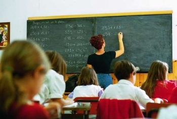 maestra alla lavagna in aula di scuola elementare